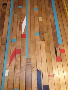 the floor is made out of wood and has different colored strips painted on each side