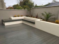 a wooden deck with benches and plants on it