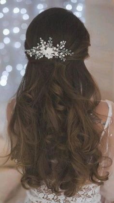 a woman wearing a wedding hair comb with flowers on it's head and long brown hair