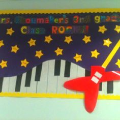 a bulletin board is decorated with stars and a rocket on it's back side