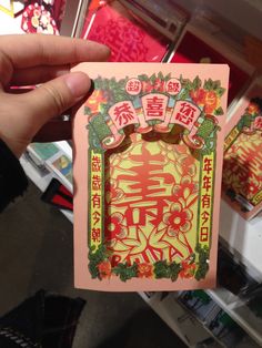 a person holding up a card with chinese writing on it