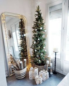 a small christmas tree sitting next to a mirror