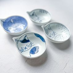 three blue and white bowls with cats painted on them