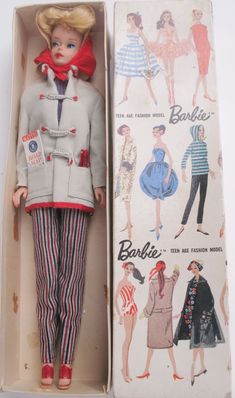 an old fashion doll in a box with its lid open to show the clothes and accessories