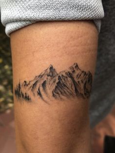 a man with a mountain tattoo on his arm