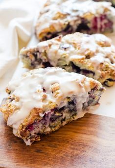 blueberry scones with white icing on a cutting board