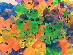 there are many different colored gummy bears in the pile together with eyes on them