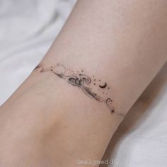 a woman's foot with a small tattoo on her left leg and the moon behind it