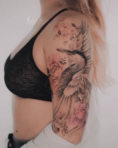 a woman with a bird tattoo on her arm and shoulder is posing for the camera