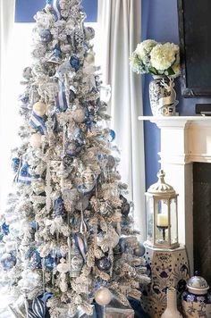 a white christmas tree with blue and silver ornaments