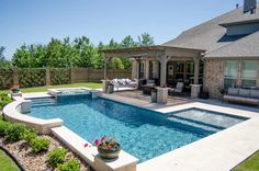 a backyard with a pool, patio and seating area in the middle of the yard