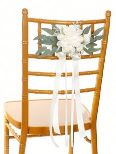 a chair with a white flower and ribbon tied to the back of it's seat