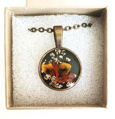 a necklace in a box with flowers on it