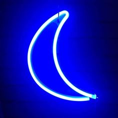 a blue neon sign hanging from the side of a building in front of a dark wall