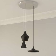 two black lamps hanging from the ceiling in a room with white walls and flooring