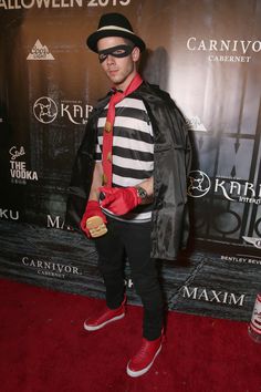 a man dressed up in a costume and mask on the red carpet at an event