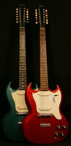 two electric guitars sitting side by side on a black background, one is red and the other is green