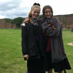 two girls standing next to each other in a field