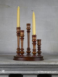 three wooden candlesticks sitting on top of a marble table next to each other