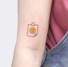 a small smiley face tattoo on the arm