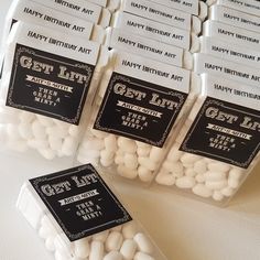 birthday party favors in plastic containers with white chocolate candies and black labels on them