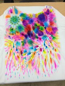 a white t - shirt with colorful paint splattered on it