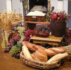 breads, grapes and other foods are arranged on a table in front of an oven