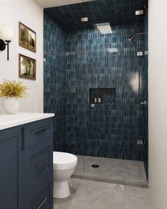 a bathroom with blue tiles on the shower wall