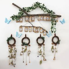 a group of wooden letters hanging from a wall next to wreaths and decorations with butterflies on them