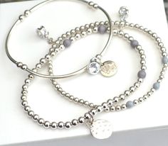 Naturals Collections Release the Inner Bohemian in you, with our Naturals Collection. 3 Set Stacking Charm Bracelets 4/5mm round Silver plated beads with Grey Agate accent beads. 3x40mm Noodle bead bracelet with 4mm beads Carrying multi Charms. Also carries our signature " Bibi EmJay" disc. 6.5" - 7" - 7.5". Please state your required size or we will presume M which is 7".  Elasticated to fit most wrists.   This can be done in Grey Agate, Black Agate, Turquoise, White Howlite, Jasper if you pref Grey Agate, White Howlite, Black Agate, Love Symbols, Bracelet Stack, Bead Bracelet, Charm Bracelets, Heart Charm, Bracelet Set