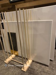 three white marble slabs with wooden sticks sticking out of them in front of a sign