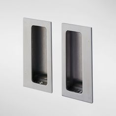 two stainless steel door handles on a white wall