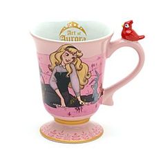 a pink coffee cup with a cartoon character on it and a red bird perched on top