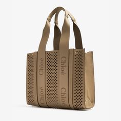 Introducing the Woody Medium Tote Bag, crafted from luxurious grained calfskin with signature perforated scallops. This spacious bag features a suede-lined compartment and practical pocket. The tonal vertical leather strips and Chloé logo embroidery add a modern touch. Comfortably carry this elevated tote on your shoulder. Chloe Logo, Elegant Bags, Backpack Travel Bag, Best Wallet, Medium Tote, Phone Bag, Wallet Bag, Womens Tote, Watch Necklace