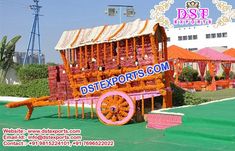 an elaborately decorated horse drawn carriage with orange and pink flowers on the sides, in front of a building