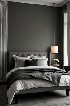 a bedroom with gray walls and white bedding, two lamps on either side of the bed