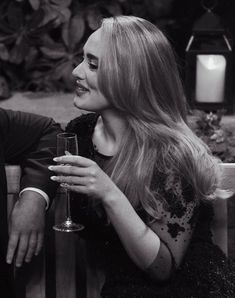 black and white photo of two people sitting on a bench with wine glasses in their hands