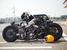 two motorcycles parked next to each other in a parking lot with a yellow cone on the ground