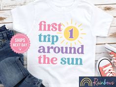 Celebrate her first trip around the sun in style! We create all of our shirts using a high quality direct to garment printing process with kid safe inks. The ink is embedded directly into the fabric so there is no cracking or peeling. We pride ourselves in quality and safety by choosing only high-quality, CPSIA compliant garments. See the boys version here: https://etsy.me/3j30iJ6 💛 IMPORTANT INFO: * All shirts and Onesies® are handmade to order, just for you! * We carry several different brand Sun Birthday, 1st Birthday Shirt, First Trip Around The Sun, Birthday Highchair, 1st Birthday Shirts, Birthday Party Shirt, Kids Graphic Tees, First Birthday Party, 1st Boy Birthday