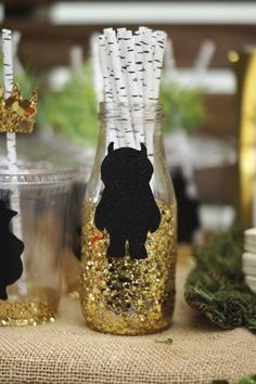 there are two vases decorated with gold glitter and black silhouettes on each one