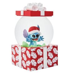 a snow globe with a stitcher doll in it sitting on top of a present box