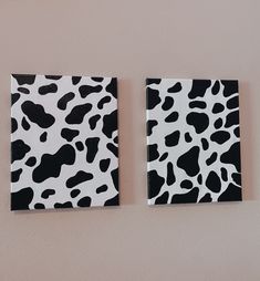 two black and white cow prints are hanging on the wall