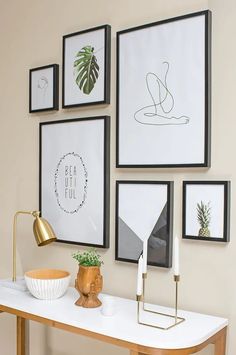 a white table topped with pictures and a gold lamp