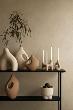 a shelf with vases and candles on it