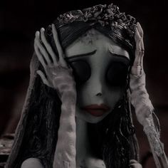 a creepy doll with her hands on her head