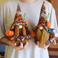 two small gnomes made out of mushrooms and carrots are held in their hands