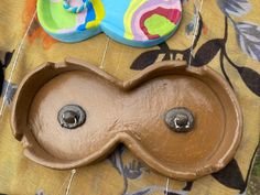 a brown sink sitting on top of a table next to a plate with donuts