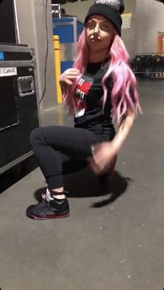 a woman with pink hair sitting on top of a skateboard in front of a machine