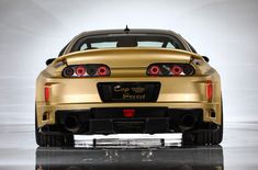 the rear end of a gold sports car