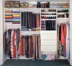 an organized closet with clothes, shoes and other items on it's shelfs